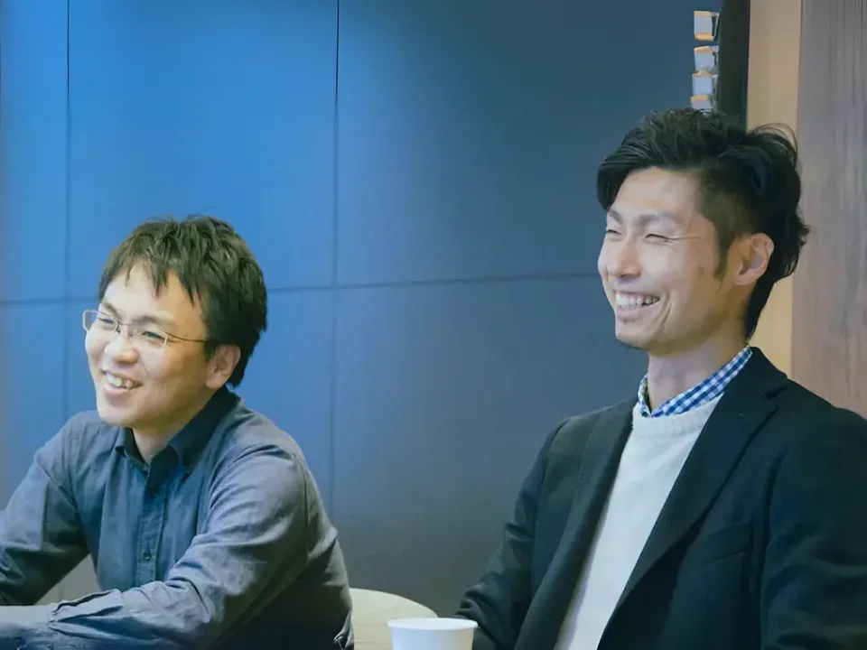 打ち合わせの合間に談笑するメンバー2人