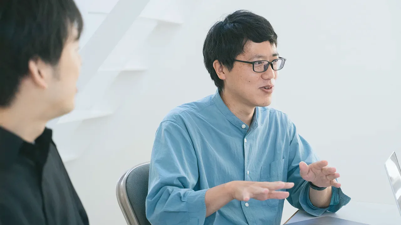 身振りを交えて説明するメンバーとそれを聞くメンバー